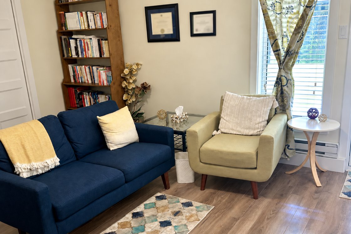 Le bureau de Christine Pagé à Terrebonne : un divan bleu, un fauteuil crème, une bibliothèque et la lumière de la fenêtre
