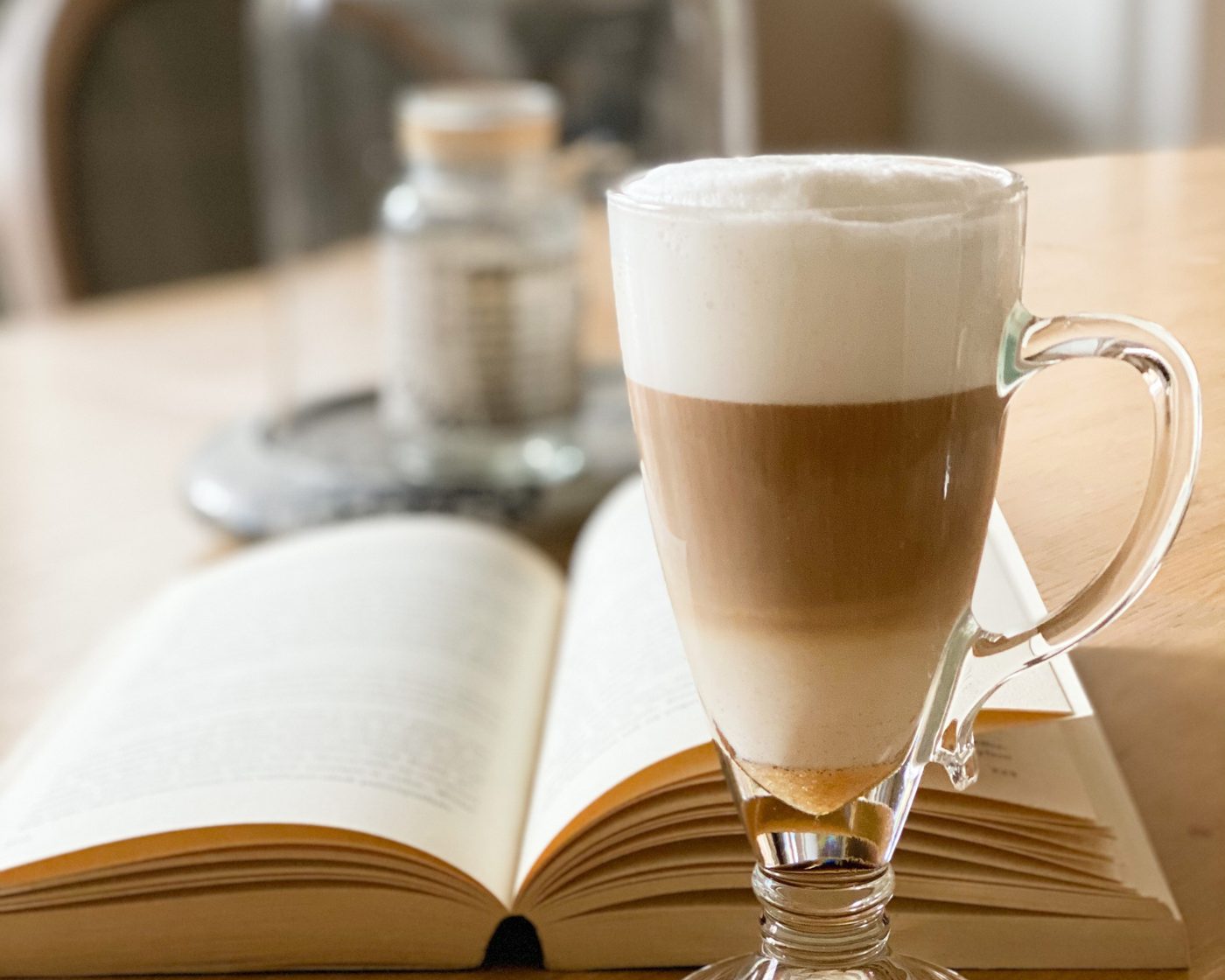 Un café au lait posé sur un livre ouvert